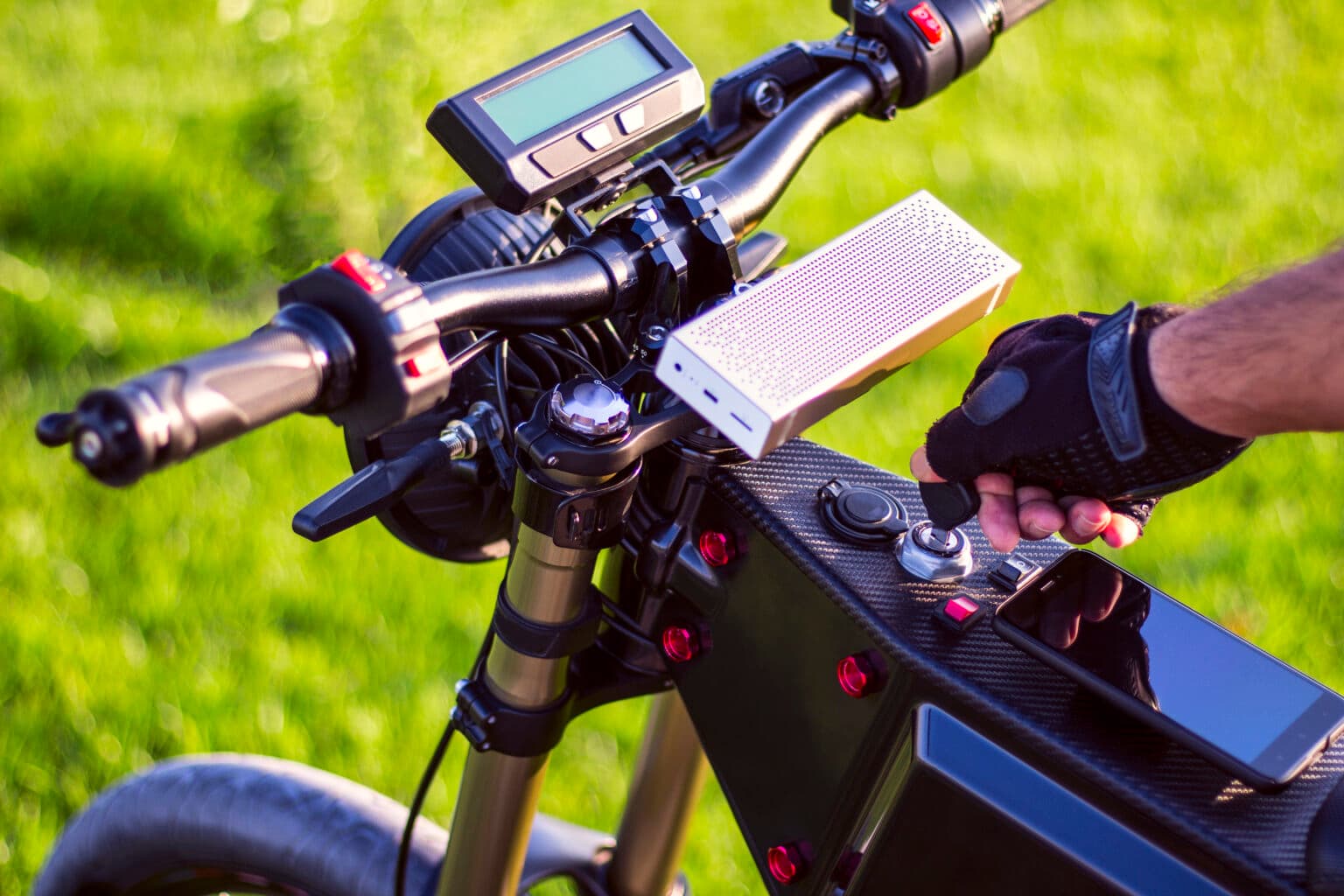 Hand am Lenker eines E-Bikes mit Display.